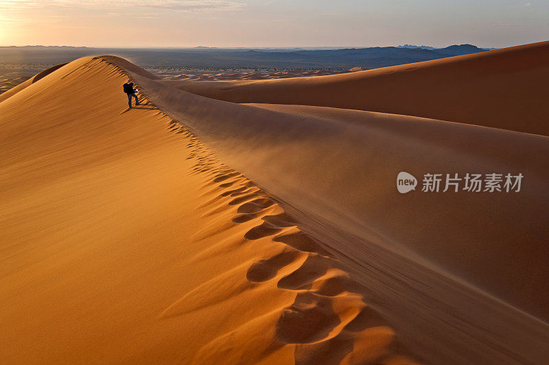 在非洲摩洛哥日出的Erg Chebbi沙丘上的人